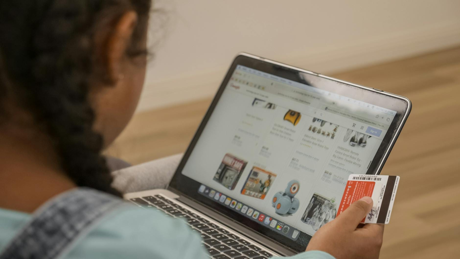 Dziecko z kartą płatniczą robi zakupy online na laptopie