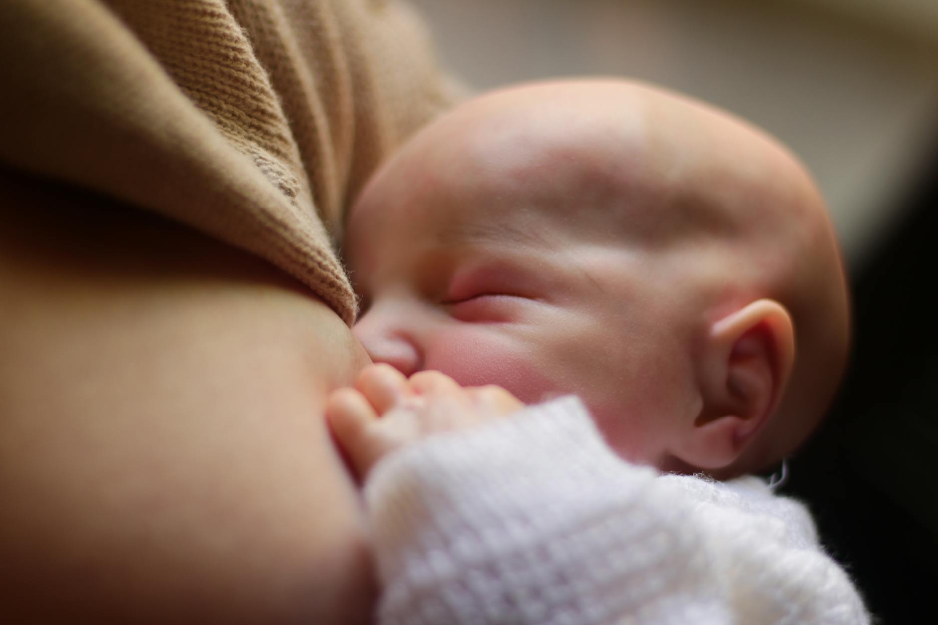 Mama karmiąca piersią noworodka w czułym, spokojnym momencie